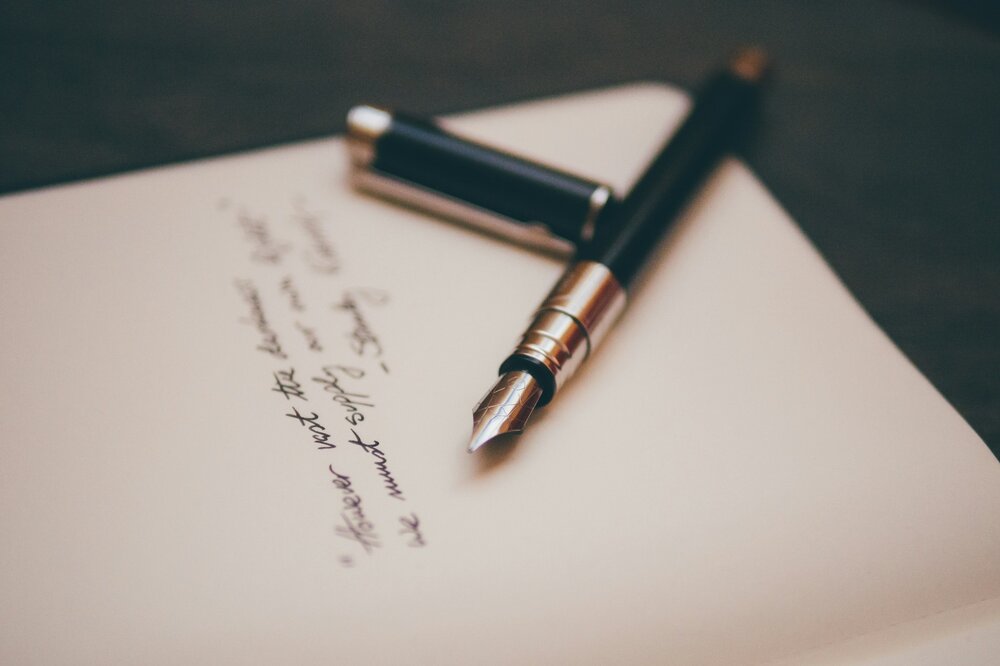 Photo of pen and handwritten text with signature